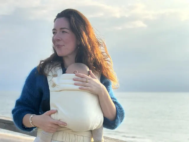 Krystyna Cordes steht an der Küste, der Wind im Haar, und trägt eine MonDoudou in Naturweiß.